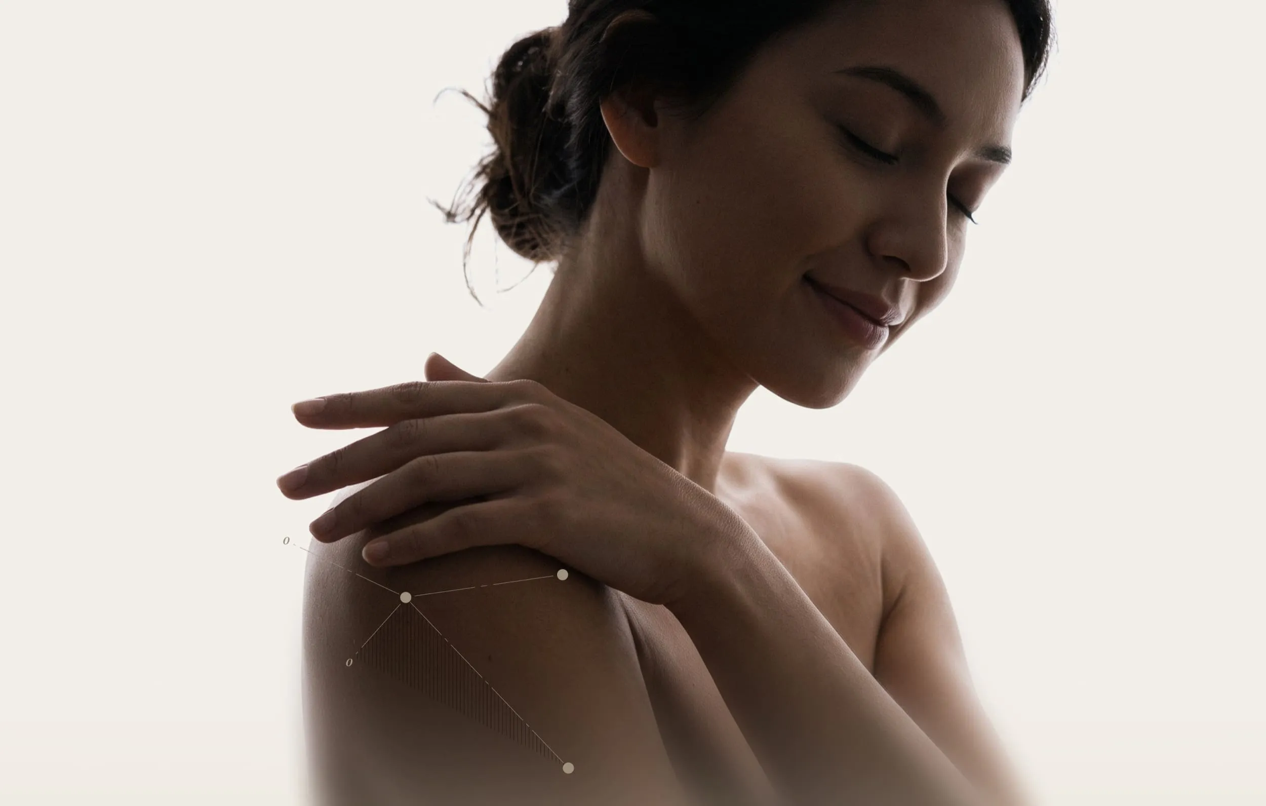 Woman gently touching opposite shoulder highlighting anatomy