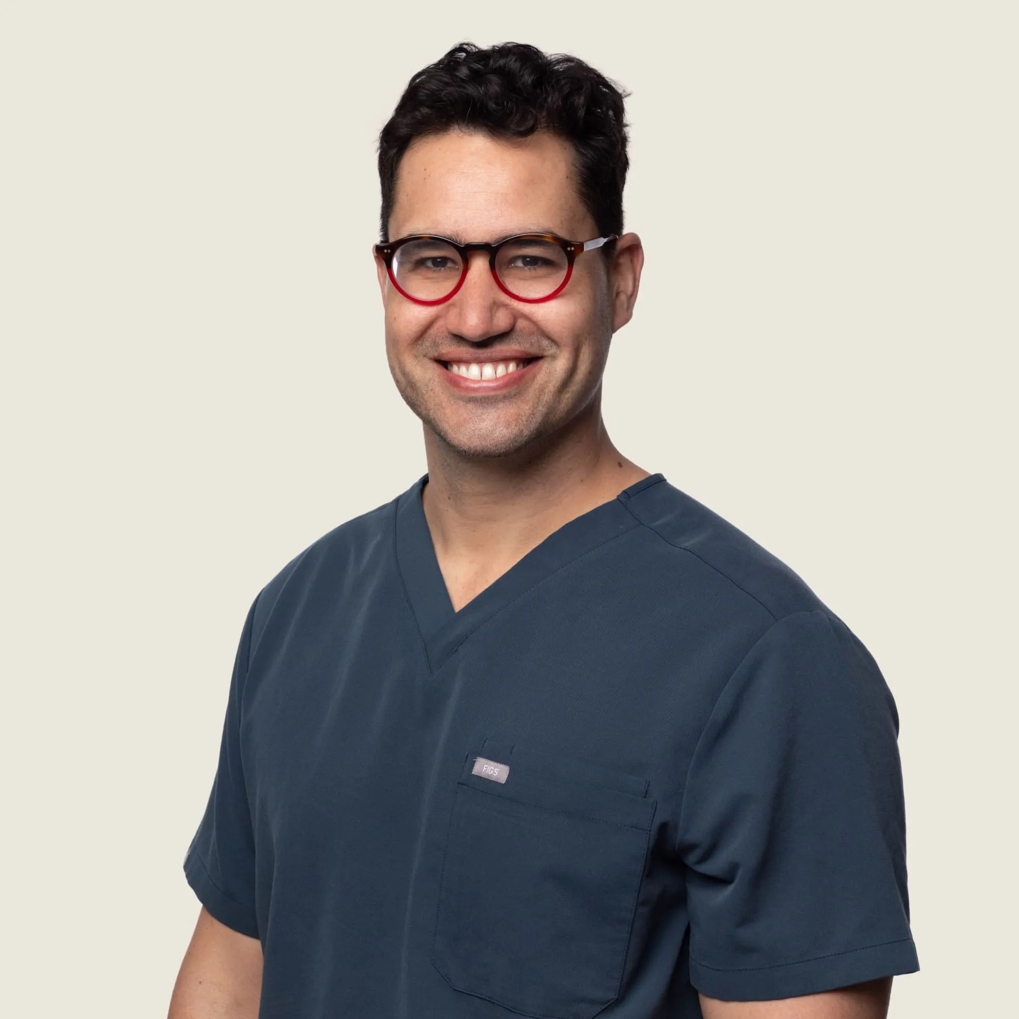Orthopaedic surgeon Dr Cameron Handford smiling in blue scrubs