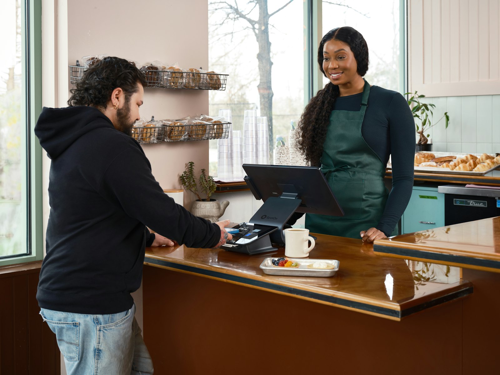 Customer checking out at a cafe counter POS station