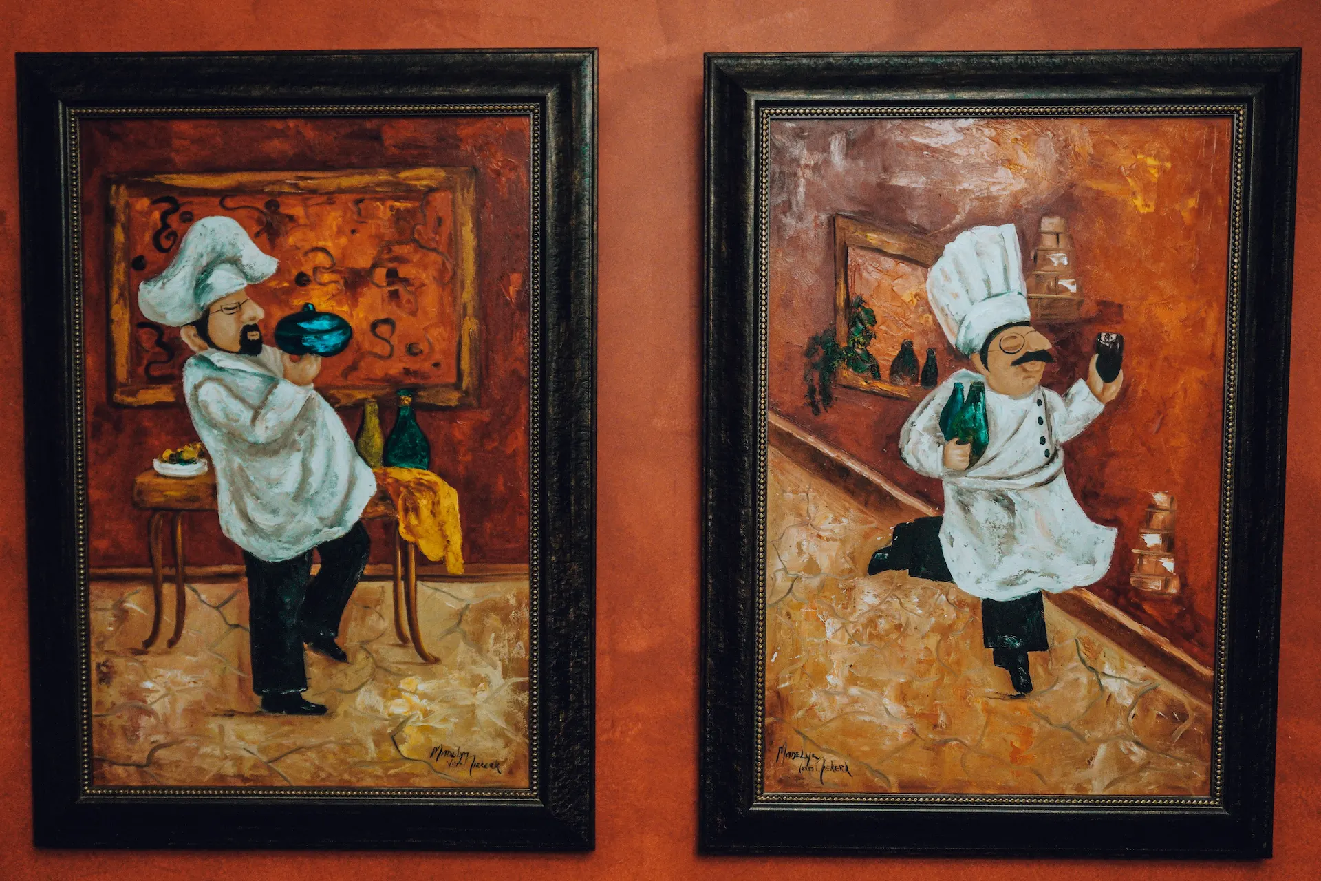 Two framed paintings of chefs in white uniforms holding food and drinks on warm-toned backgrounds hanging inside St. Joseph's Bed and Breakfast in Irenepark, Klerksdorp