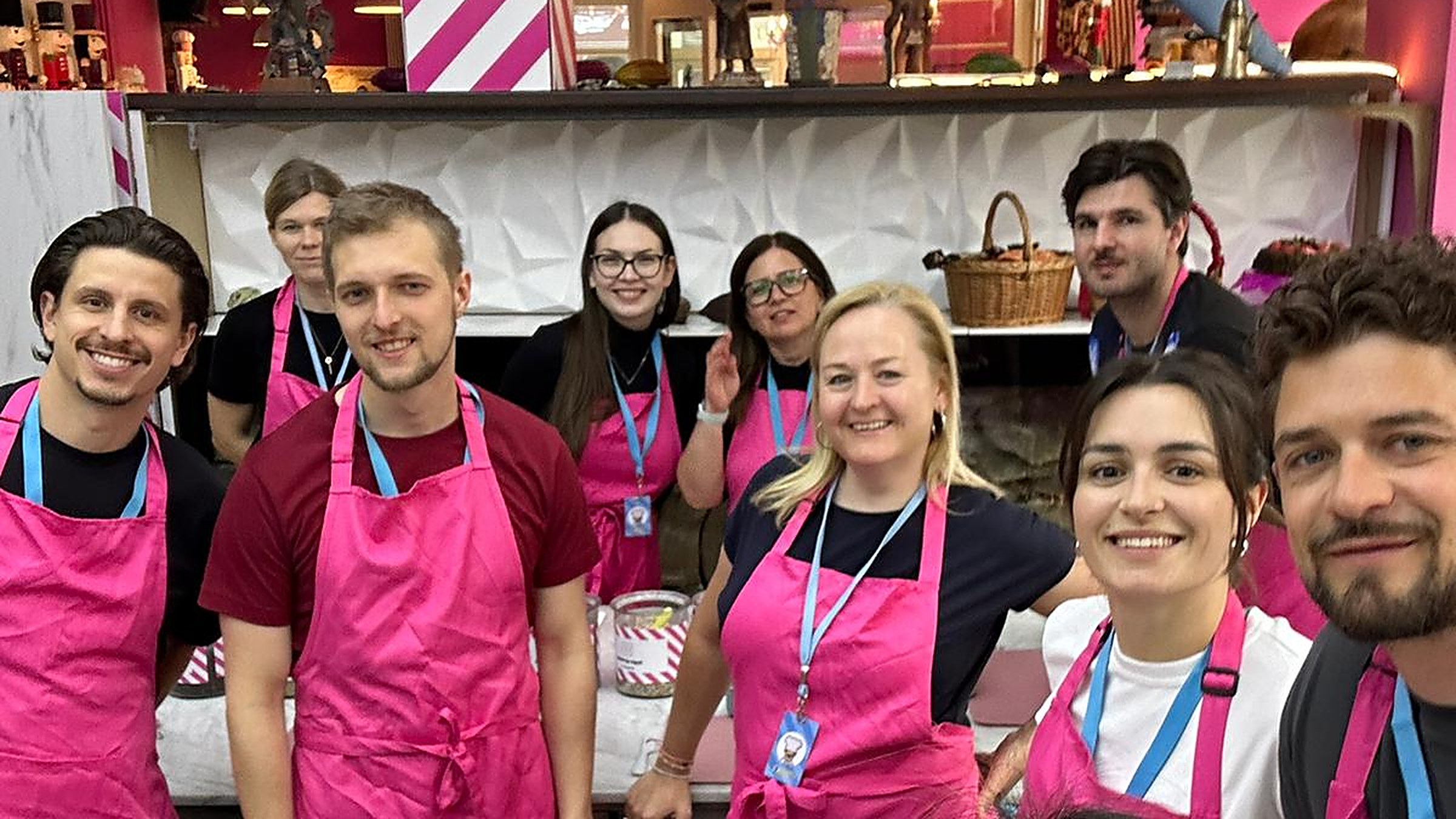 The Emarket team wearing pink aprons at a team event