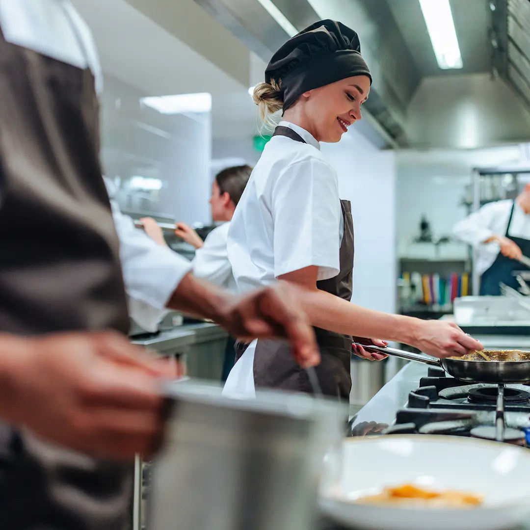 Cuisine professionnelle en plein coup de feu avec extraction au-dessus des fourneaux.