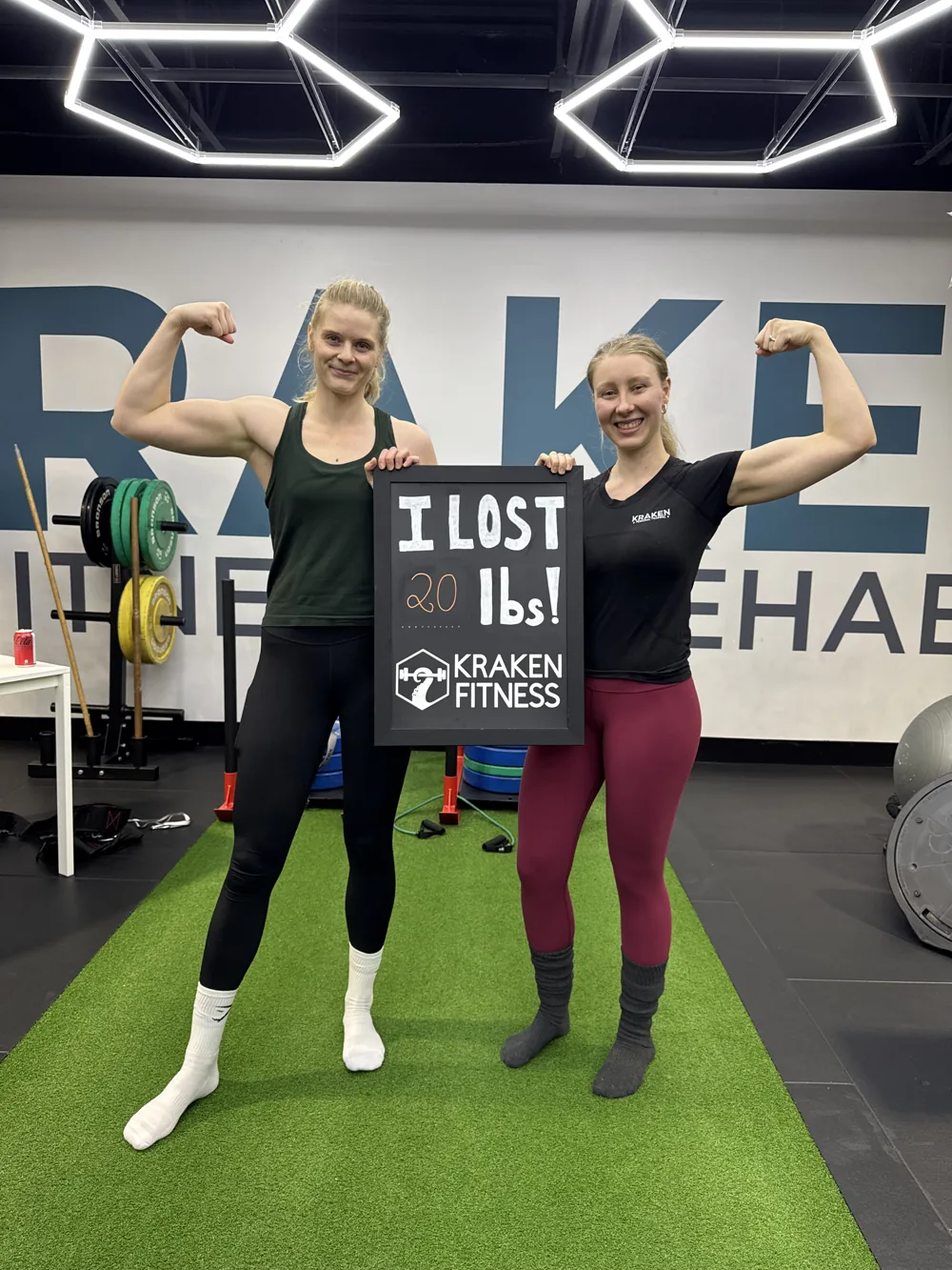 Janelle holding an I lost 20 lbs chalkboard at Kraken Fitness