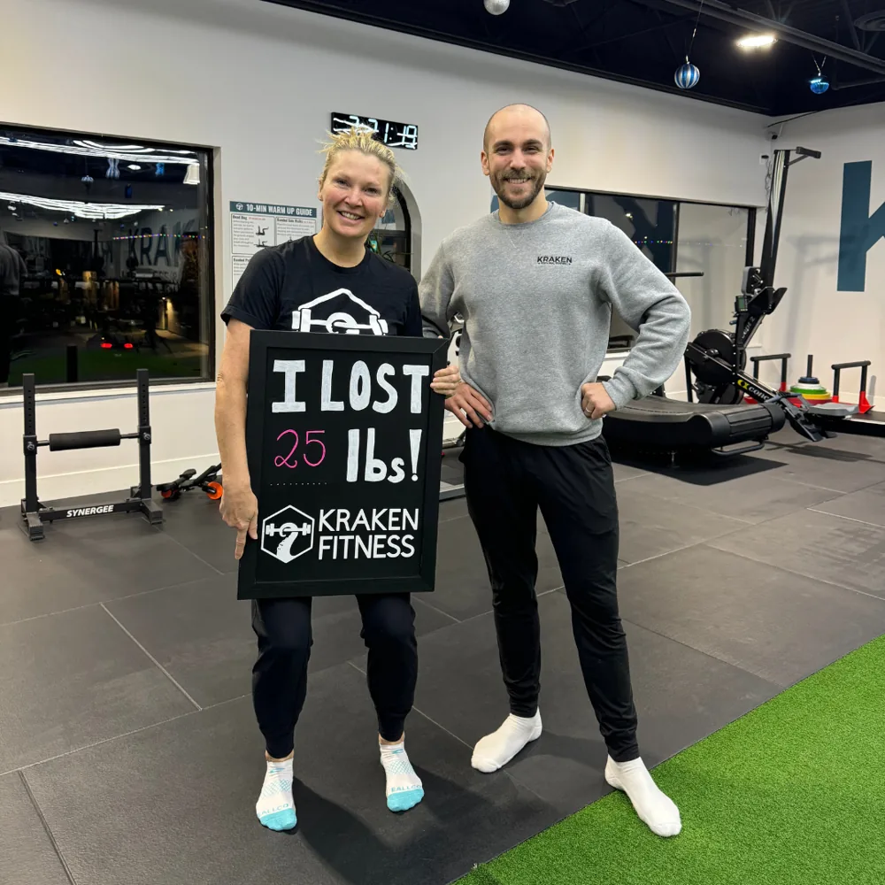 Stacia holding an I lost 25 lbs chalkboard at Kraken Fitness