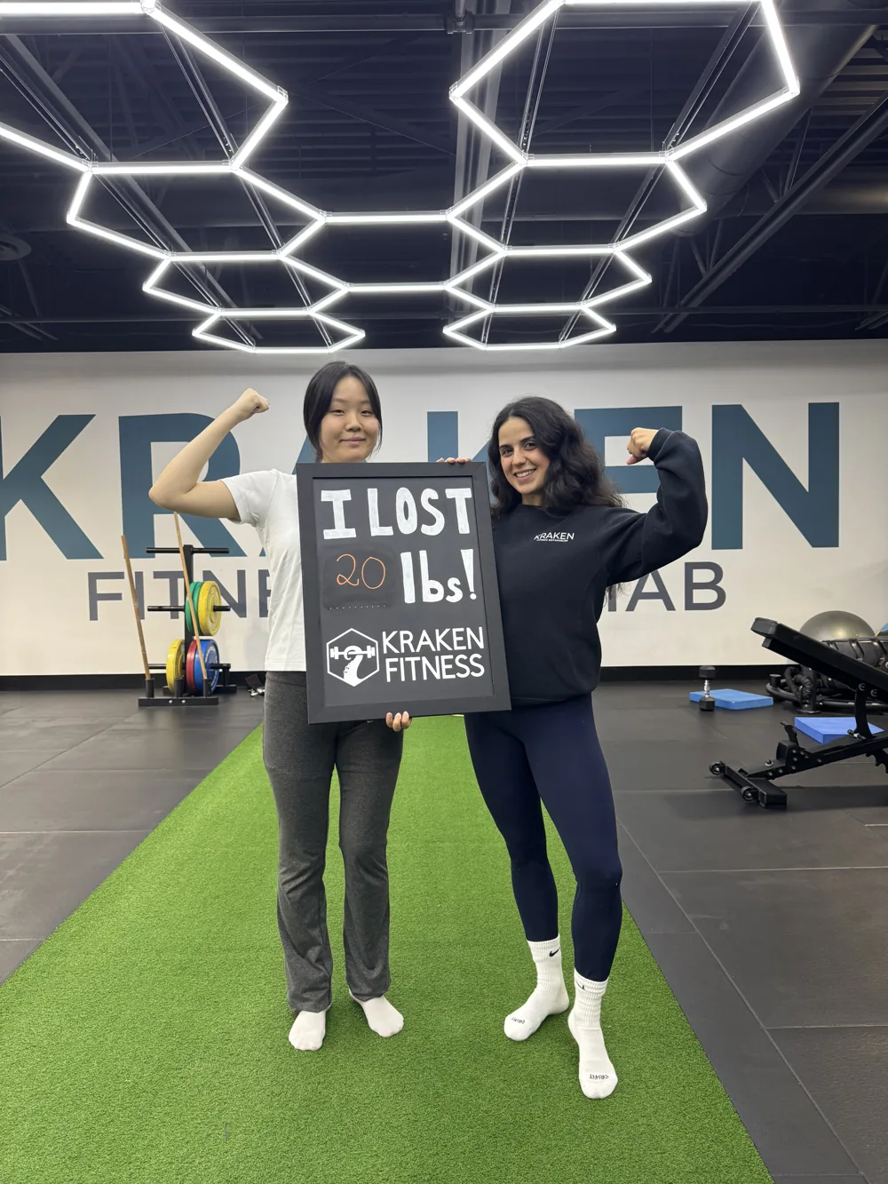 Raina holding an I lost 20 lbs chalkboard at Kraken Fitness
