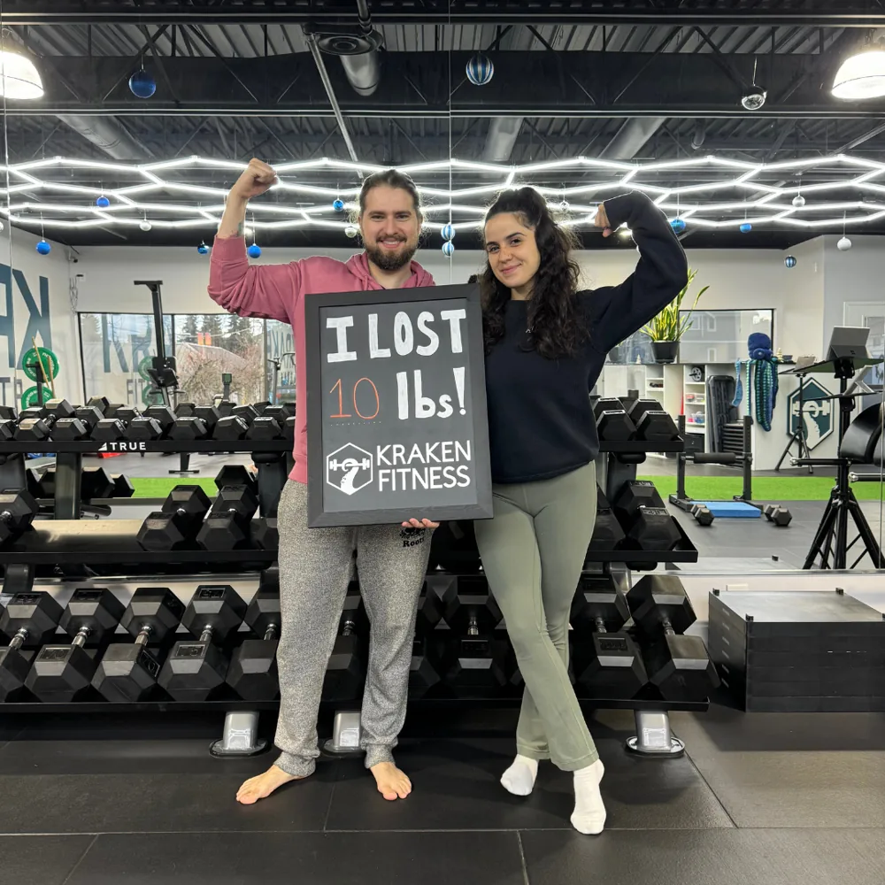 Joao holding an I lost 10 lbs chalkboard at Kraken Fitness