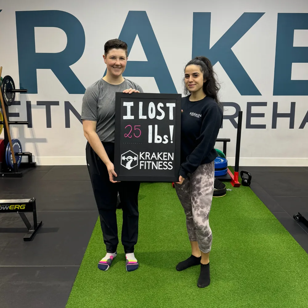 Flo holding an I lost 25 lbs chalkboard at Kraken Fitness