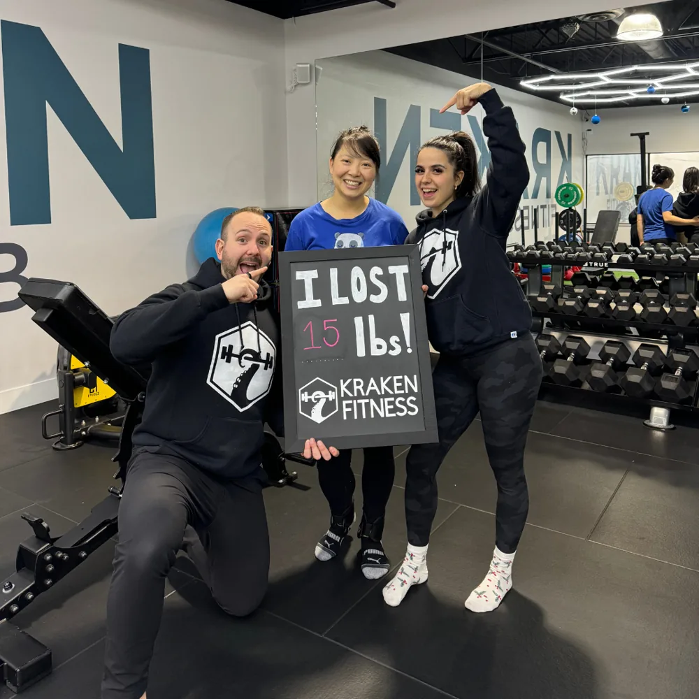 Katie holding an I lost 15 lbs chalkboard at Kraken Fitness