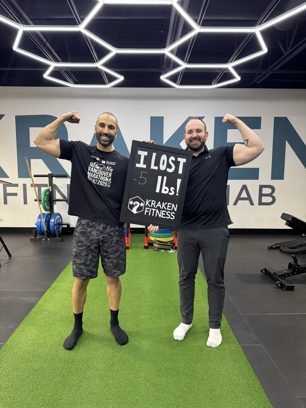 Paul holding an I lost 5 lbs chalkboard at Kraken Fitness