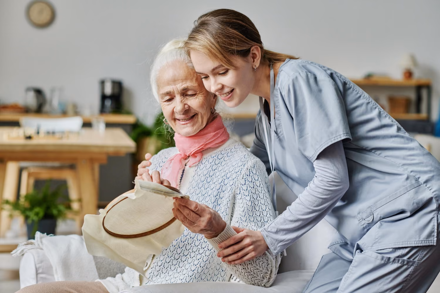 Pflegekraft unterstützt eine Seniorin beim Essen