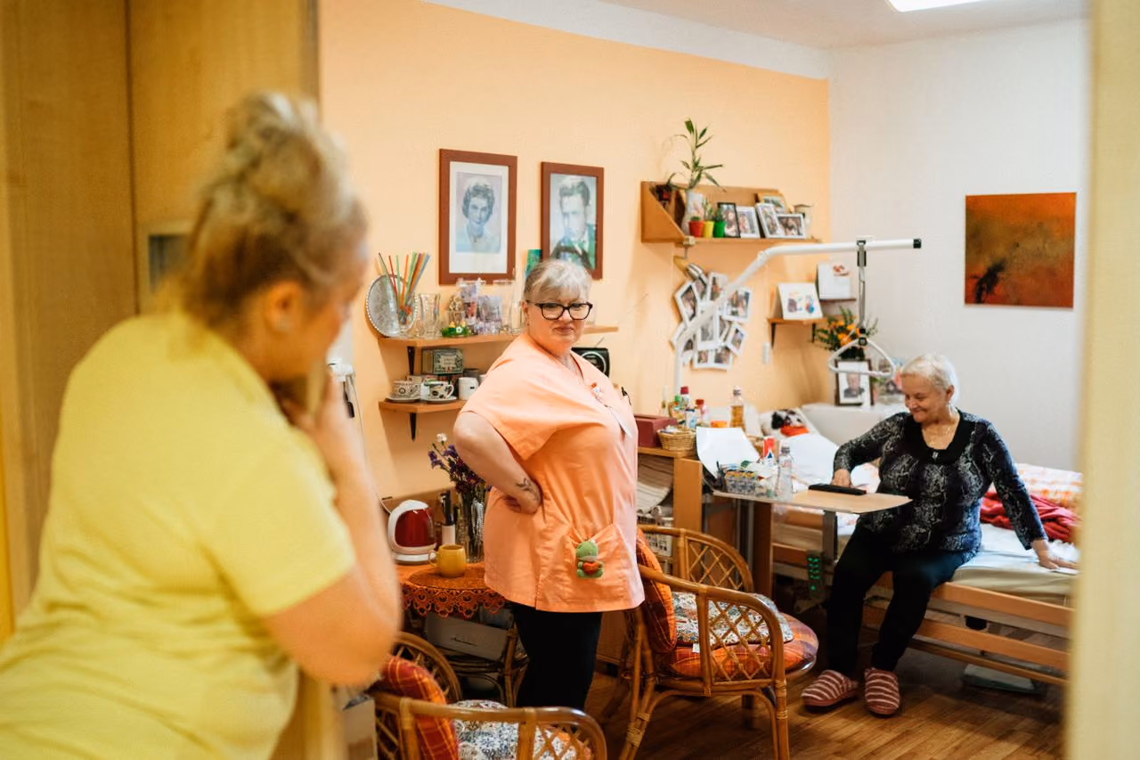 Pflegekraft im Gespräch mit Bewohnerin einer Pflegeeinrichtung