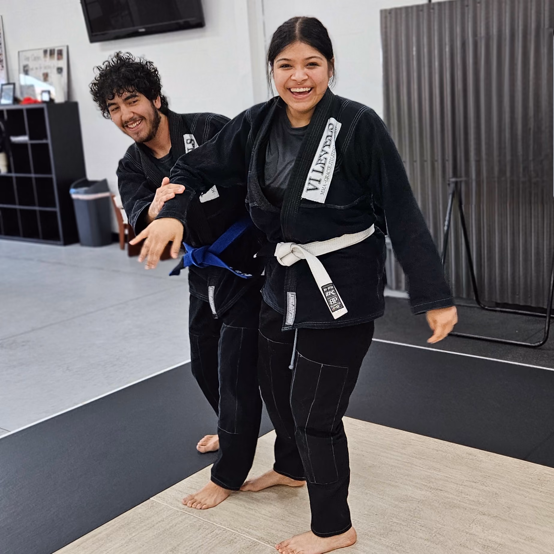 Two martial artists in black and white karate attire pose in a dynamic fighting stance.