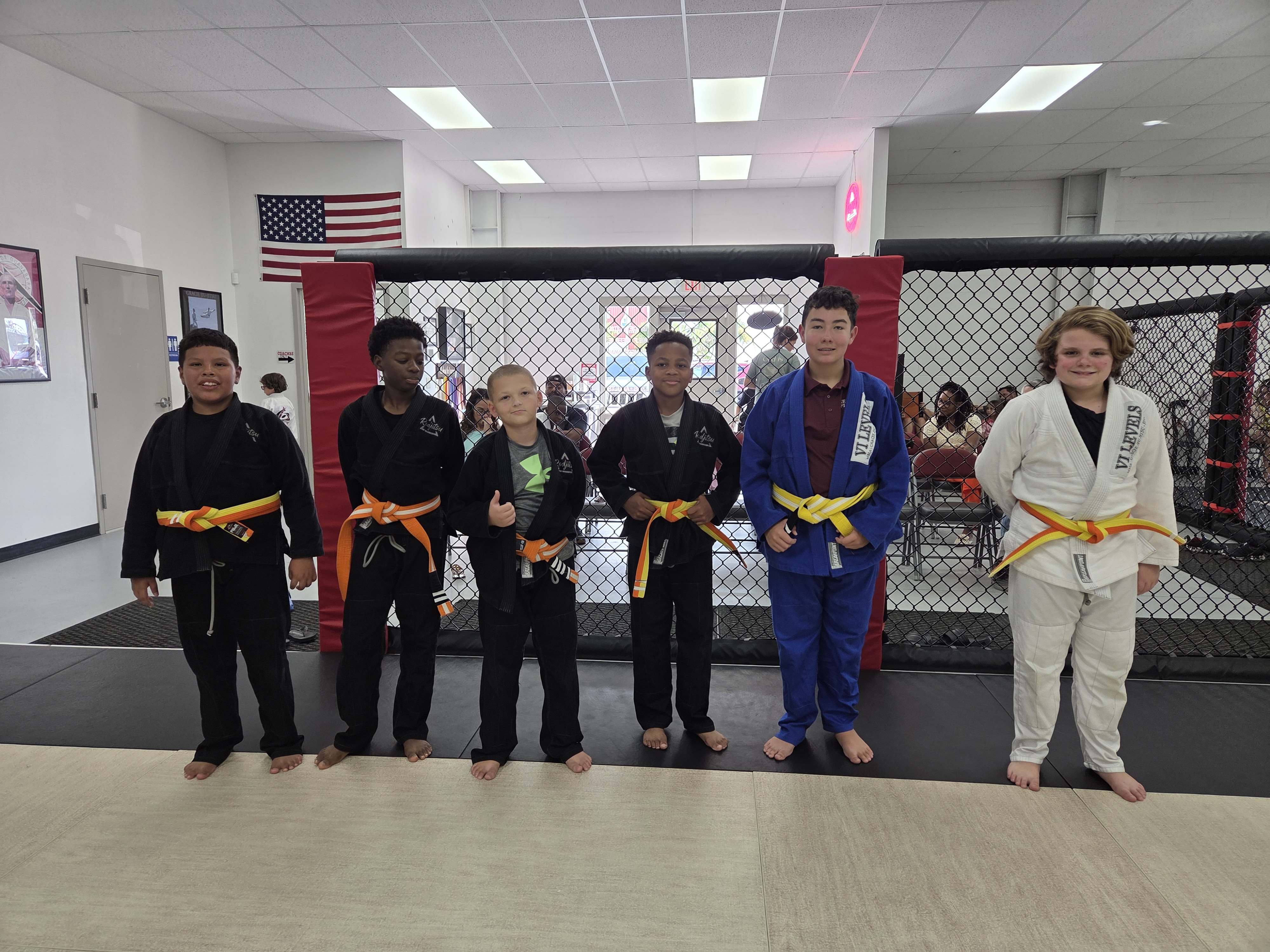 A group of children in karate uniforms smiling and posing together for a photo.