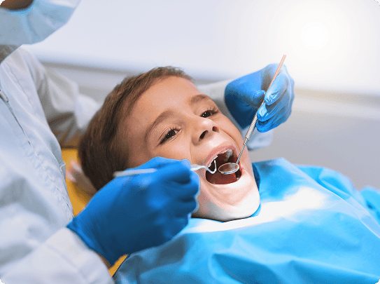 Smiling man sitting in a dental chair giving a thumbs-up in a bright dental office.