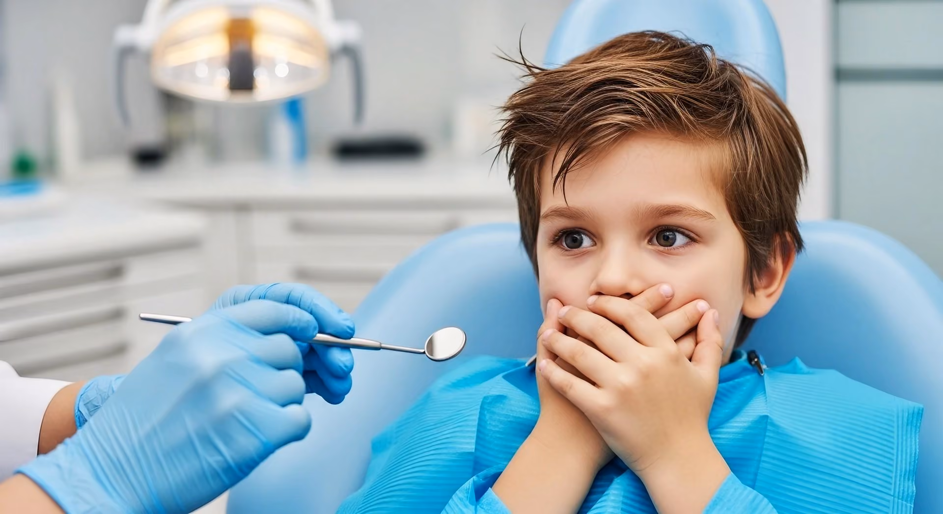 Smiling man sitting in a dental chair giving a thumbs-up in a bright dental office.