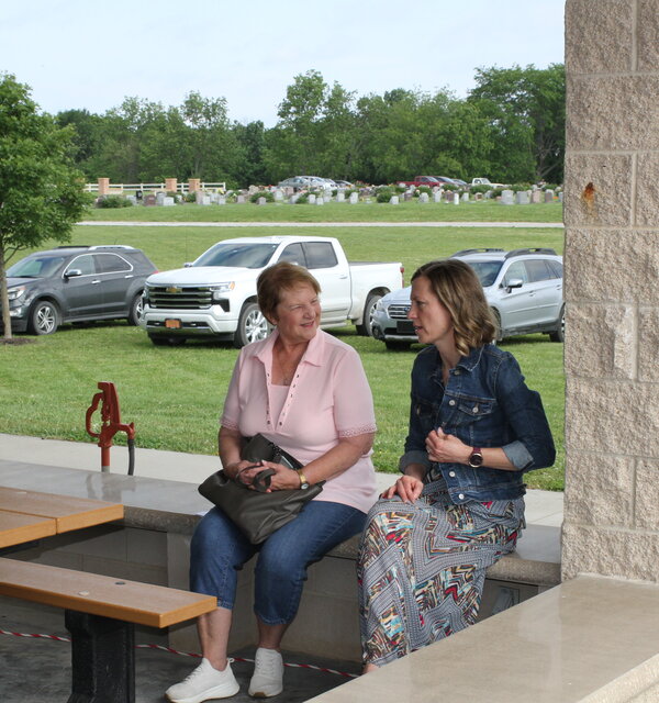 Two women sit on a bench at the Shelter House in Paola, Kansas.