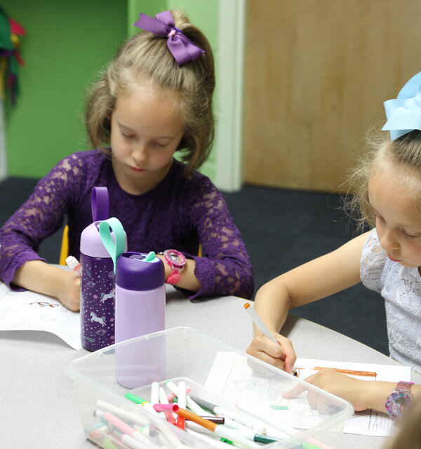 Two little girls color during Sunday school at Trinity Lutheran Church in Paola, Kansas. 