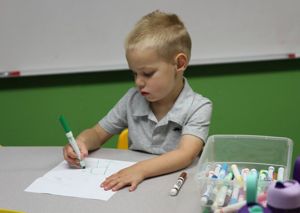 A blonde Sunday School student at Trinity Lutheran Church in Paola, Kansas colors. 