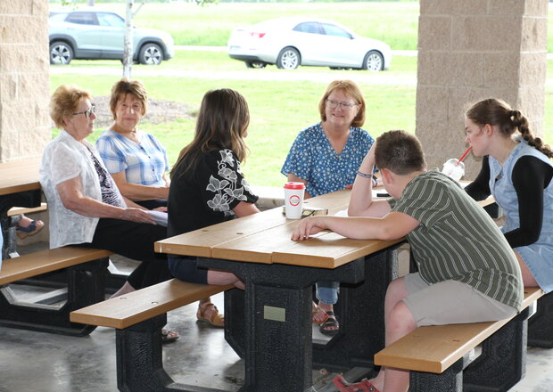 Members at Trinity Lutheran Church in Paola, Kansas meet at a table in the Shelter House for fellowship.