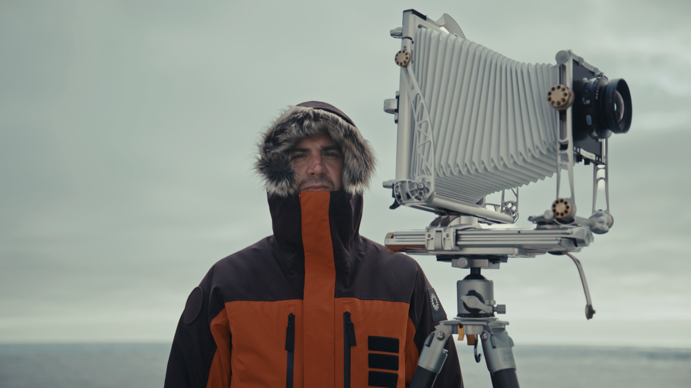 Niccolò Banfi beside a large-format camera on the open sea