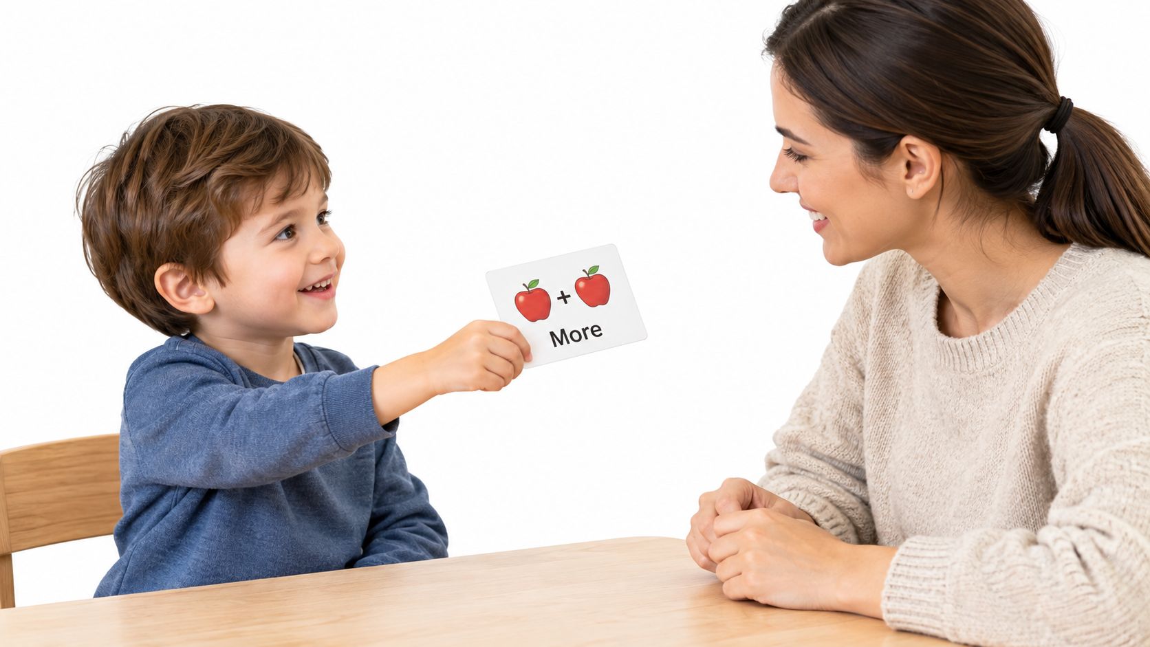 A young boy holds up an educational flashcard showing two apples and the word More to his mother.