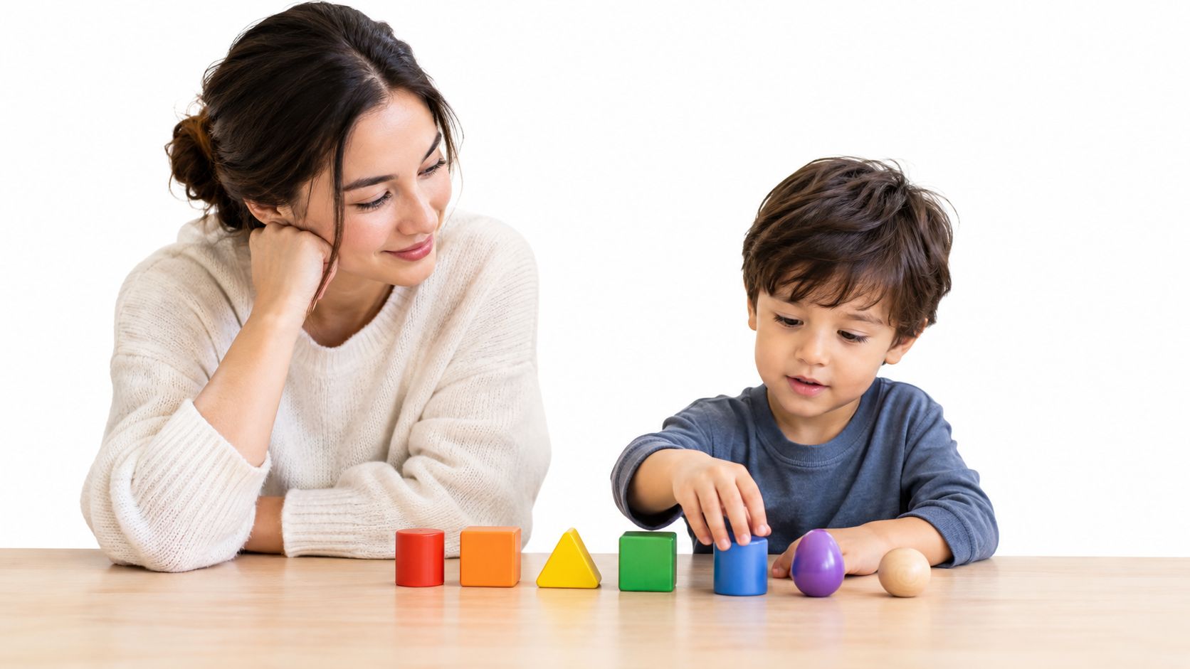 A young child engages in an applied behavior analysis assessment with their mother using colorful wooden blocks.