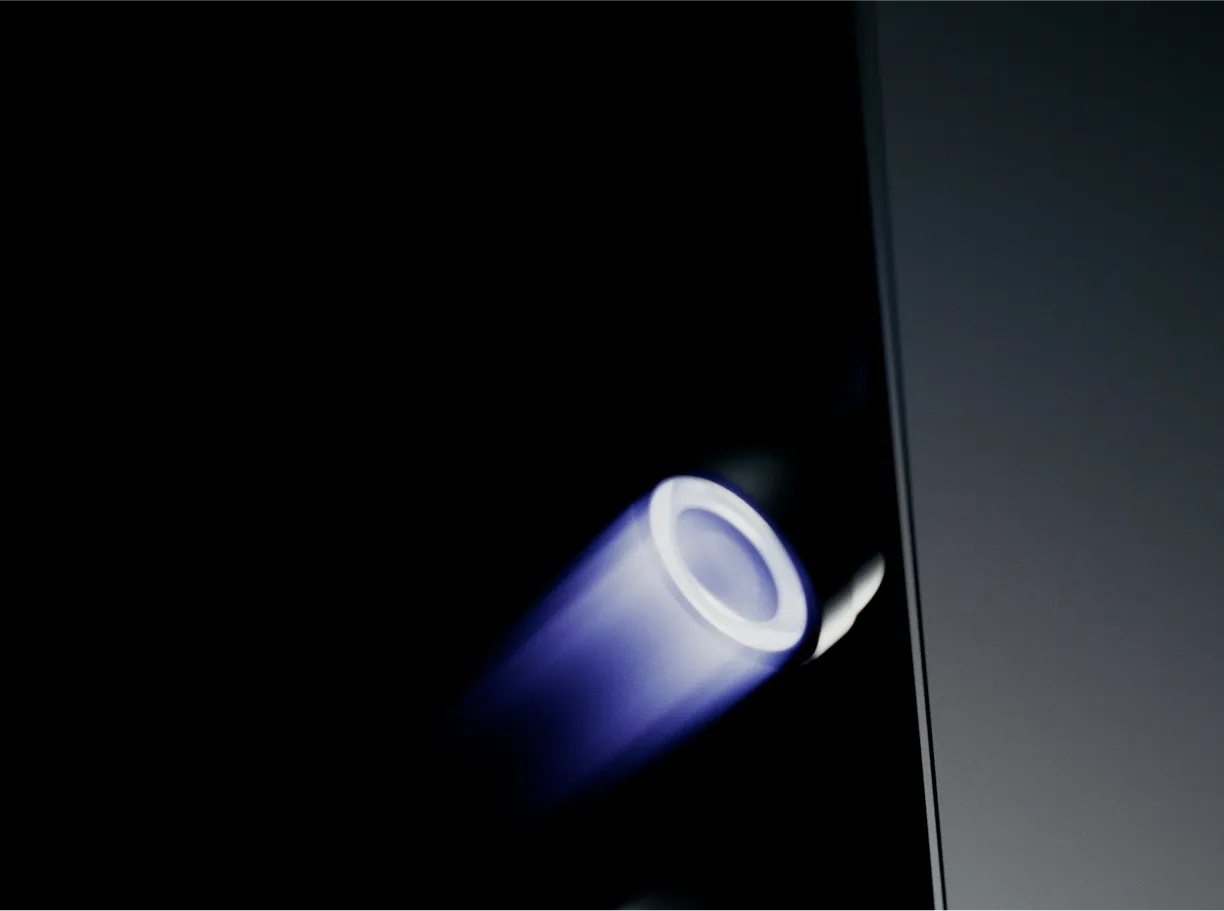 Close-up of a glowing circular light emitting soft blue light in a dark space.