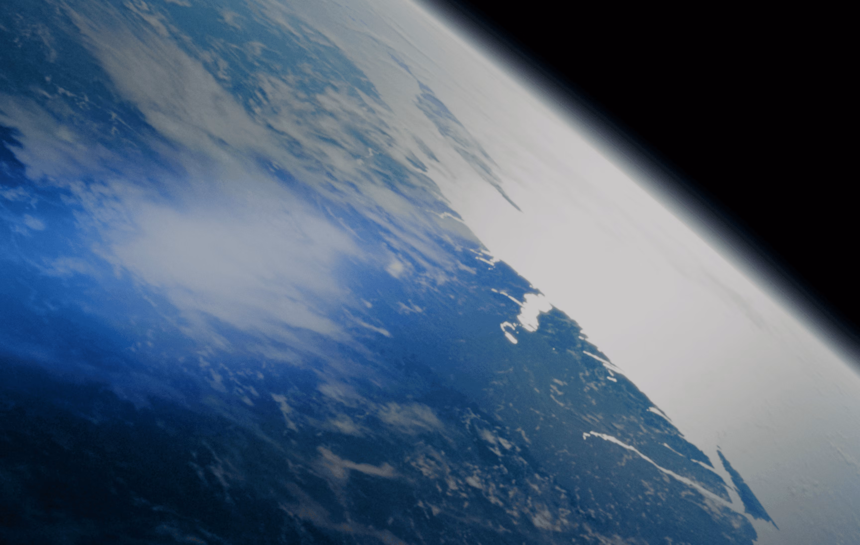 View of Earth from space showing clouds, ocean, and a polar ice cap on the horizon.