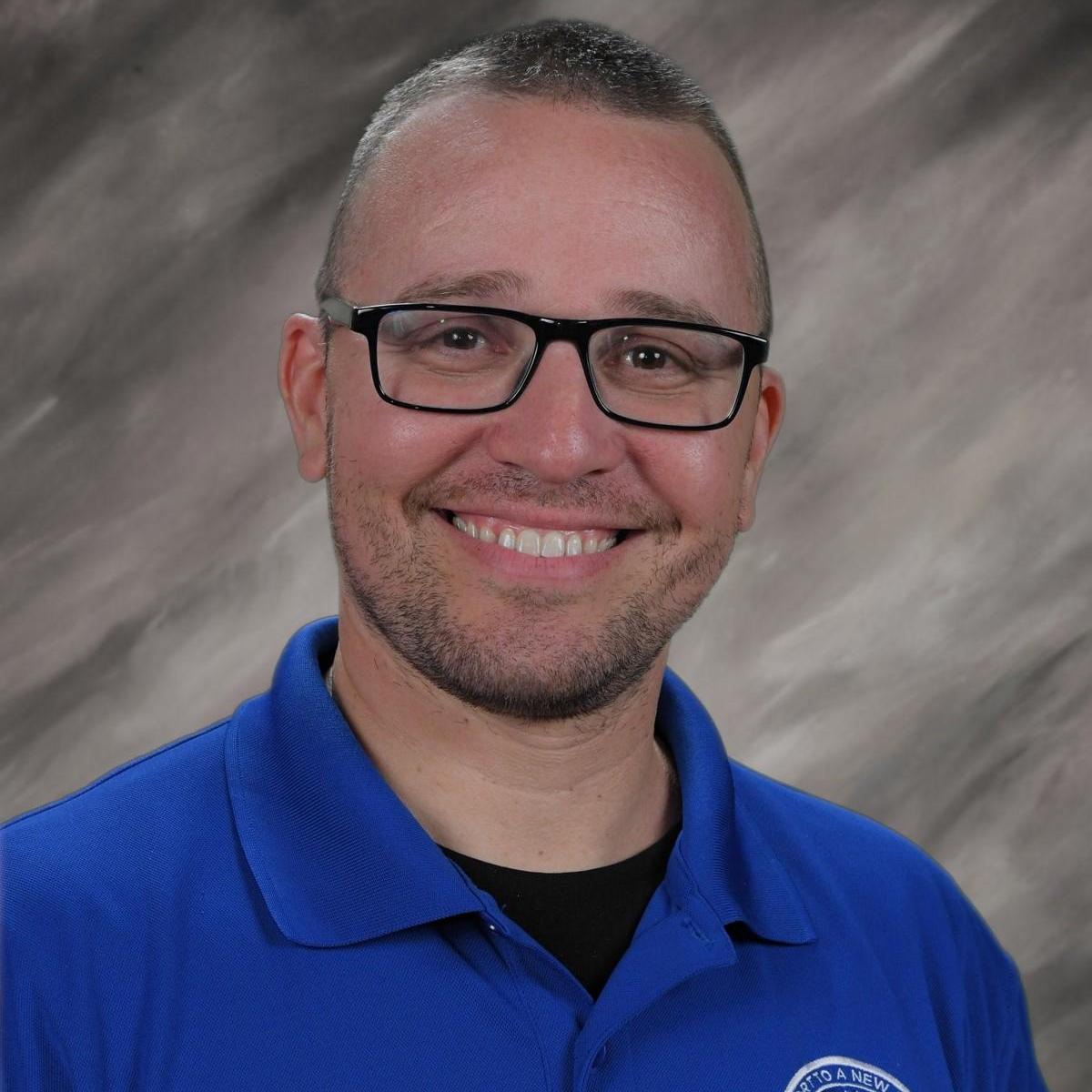 Jeffrey Cohen staff portrait photo in blue school polo