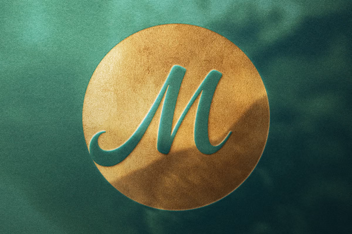 Green background with a gold circular emblem featuring a raised green letter M.