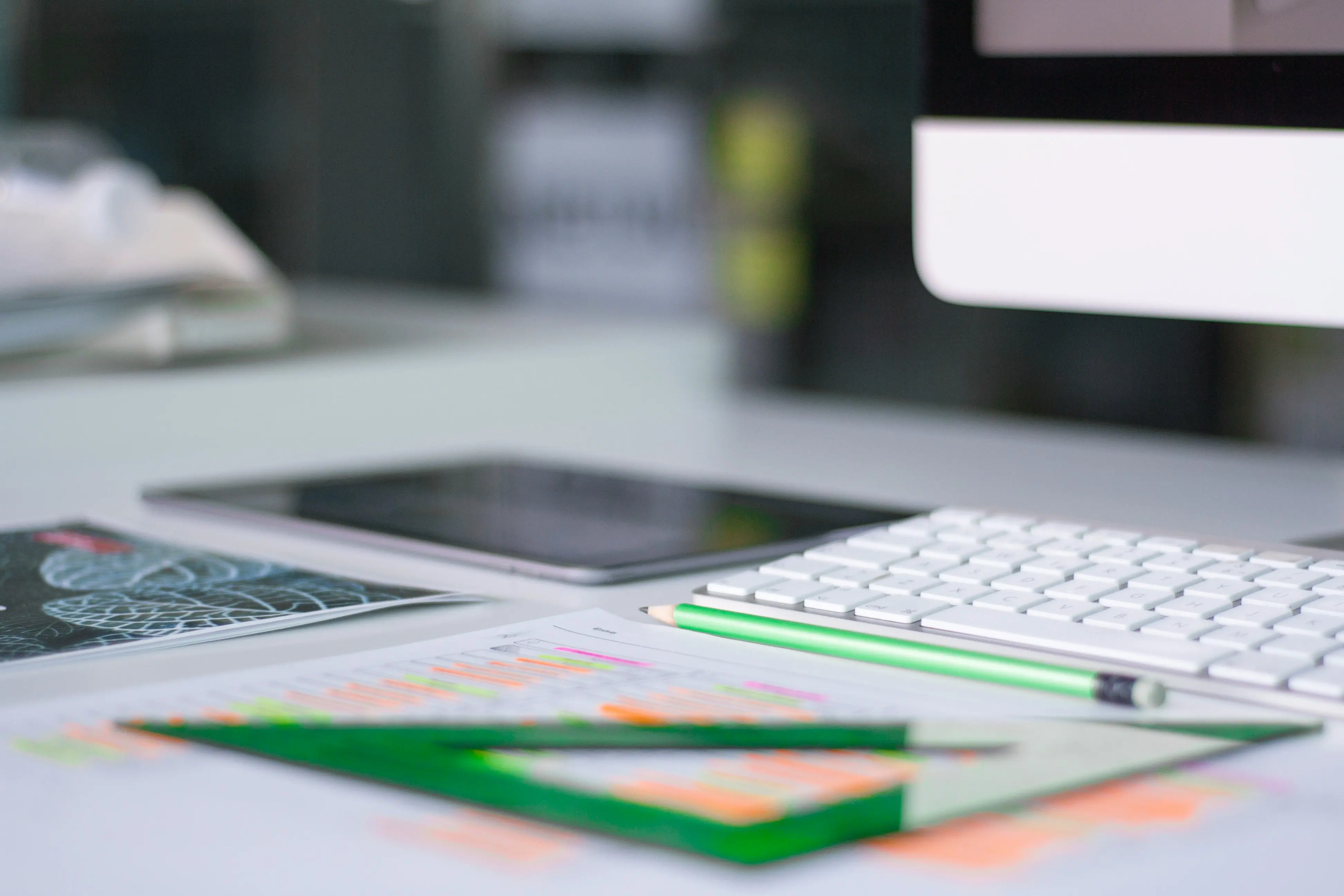 A desk with a tablet, keyboard, and phone