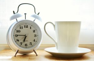 White alarm clock and white mug