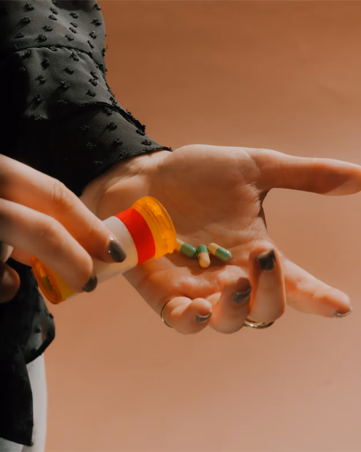 Hand pouring antidepressant capsules from a prescription bottle