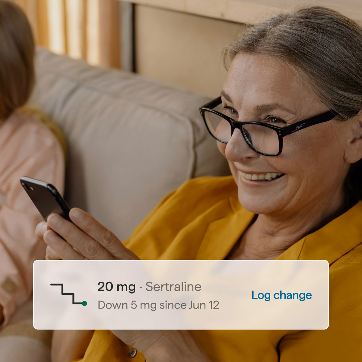 Woman smiling at the Outro Health app after logging a sertraline dose reduction