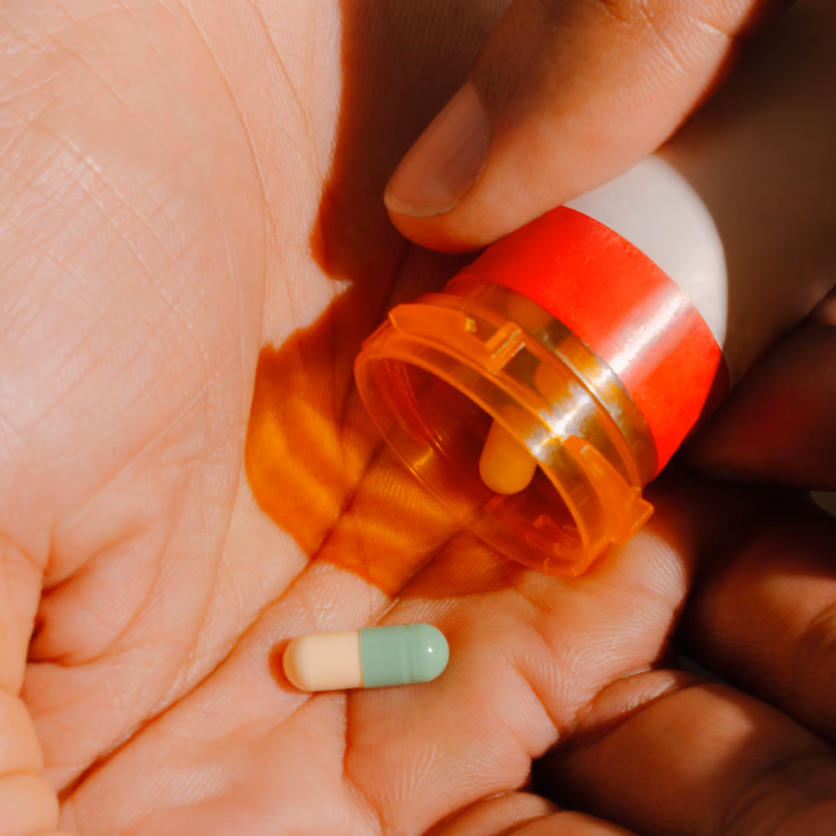 Antidepressant capsule poured from a prescription bottle into an open palm