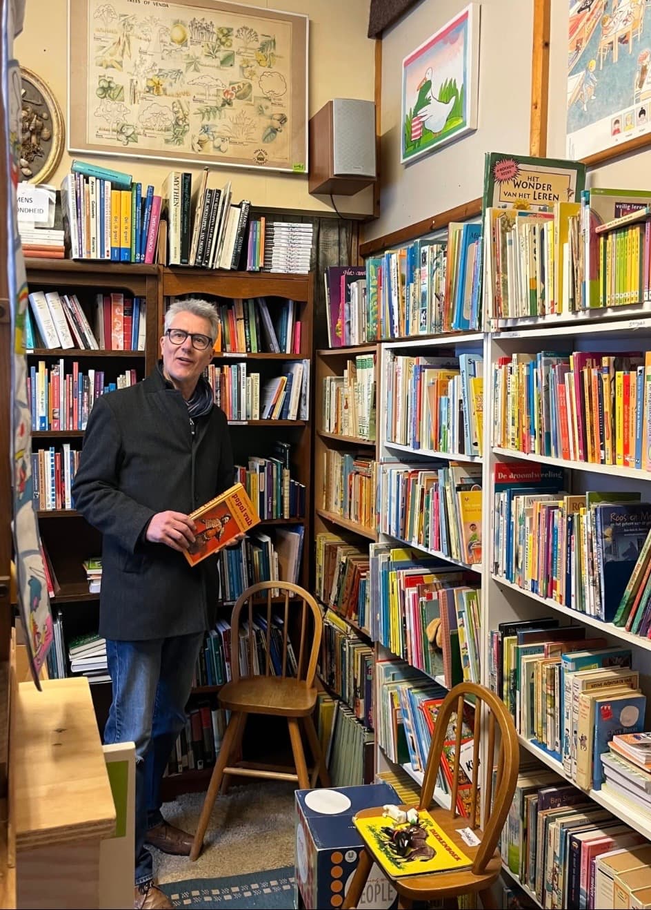Vrijwilliger tussen de kinderboeken bij Weggeefwinkel Amersfoort