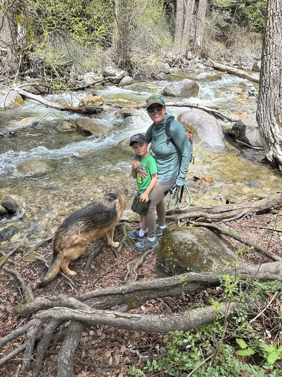 Nicki hiking a Colorado creek trail with her son and their dog
