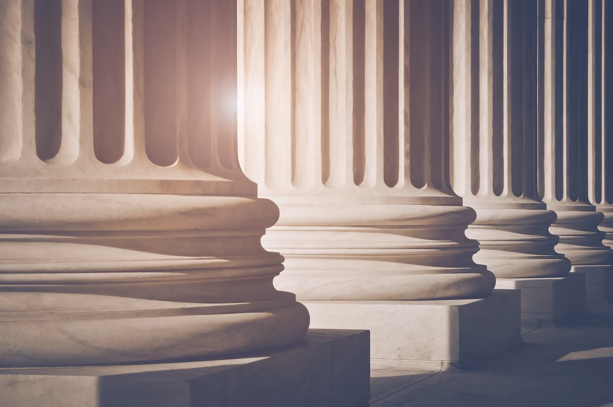 Close-up of tall neoclassical stone columns lit by sunlight, symbolizing the institutional-quality structure of SummitView Holdings' investment platform.