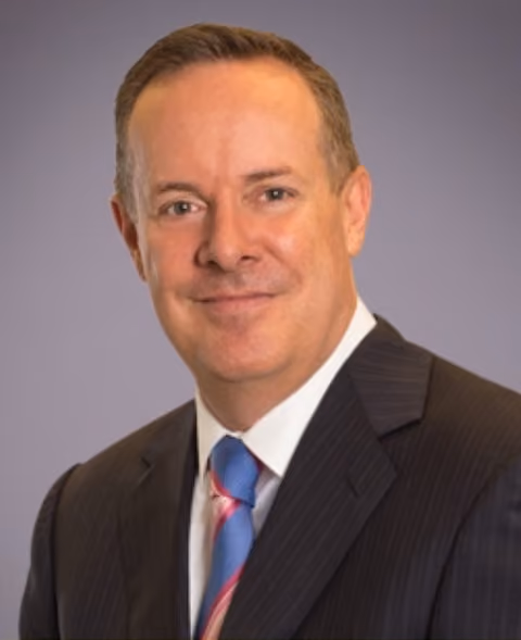 Headshot of Frank Muller, Founder and Chief Executive Officer of SummitView Holdings, wearing a dark suit and blue tie.