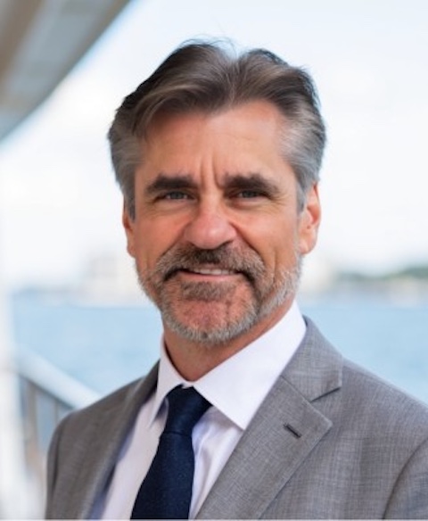 Headshot of Phillip Cooper, Chief Corporate Development Officer at SummitView Holdings, wearing a navy blazer outdoors.