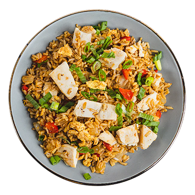 Plate of chicken fried rice with vegetables and chopped green onions on top.