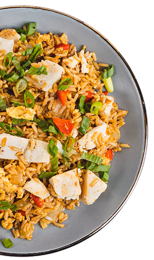 Plate of chicken fried rice with green onions, red bell pepper, and scrambled eggs.