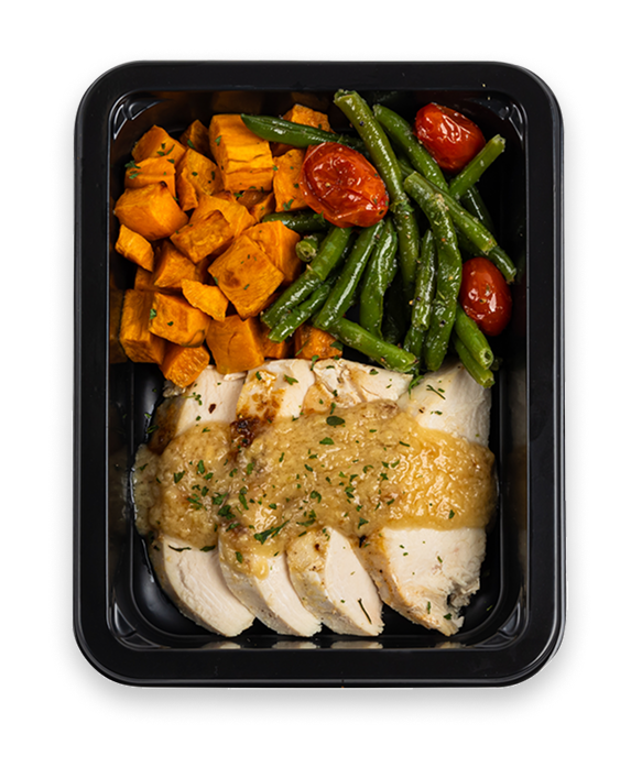 Grilled chicken slices with lemon garlic sauce, green beans, cherry tomatoes, and diced sweet potatoes in a black container.