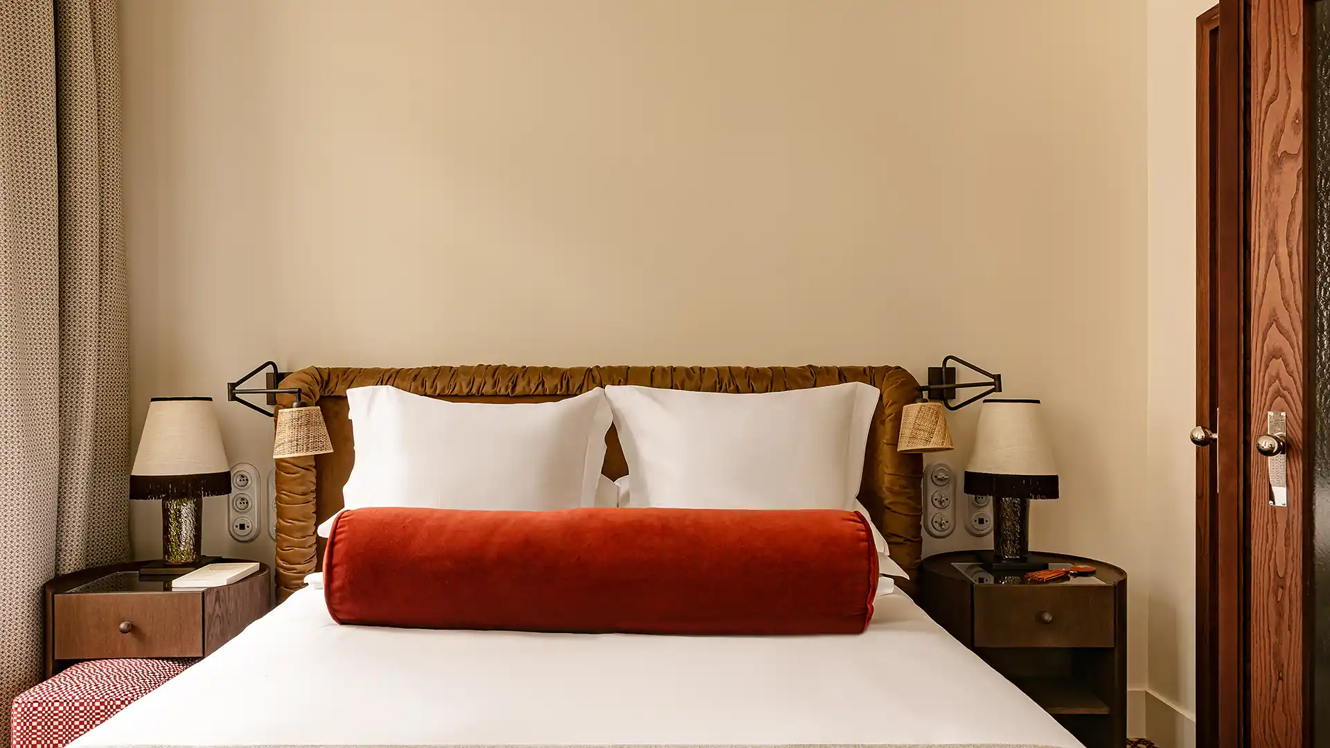 Tête de lit face avec coussin bolster orange oreillers blancs et tables de chevet symétriques Château des Fleurs