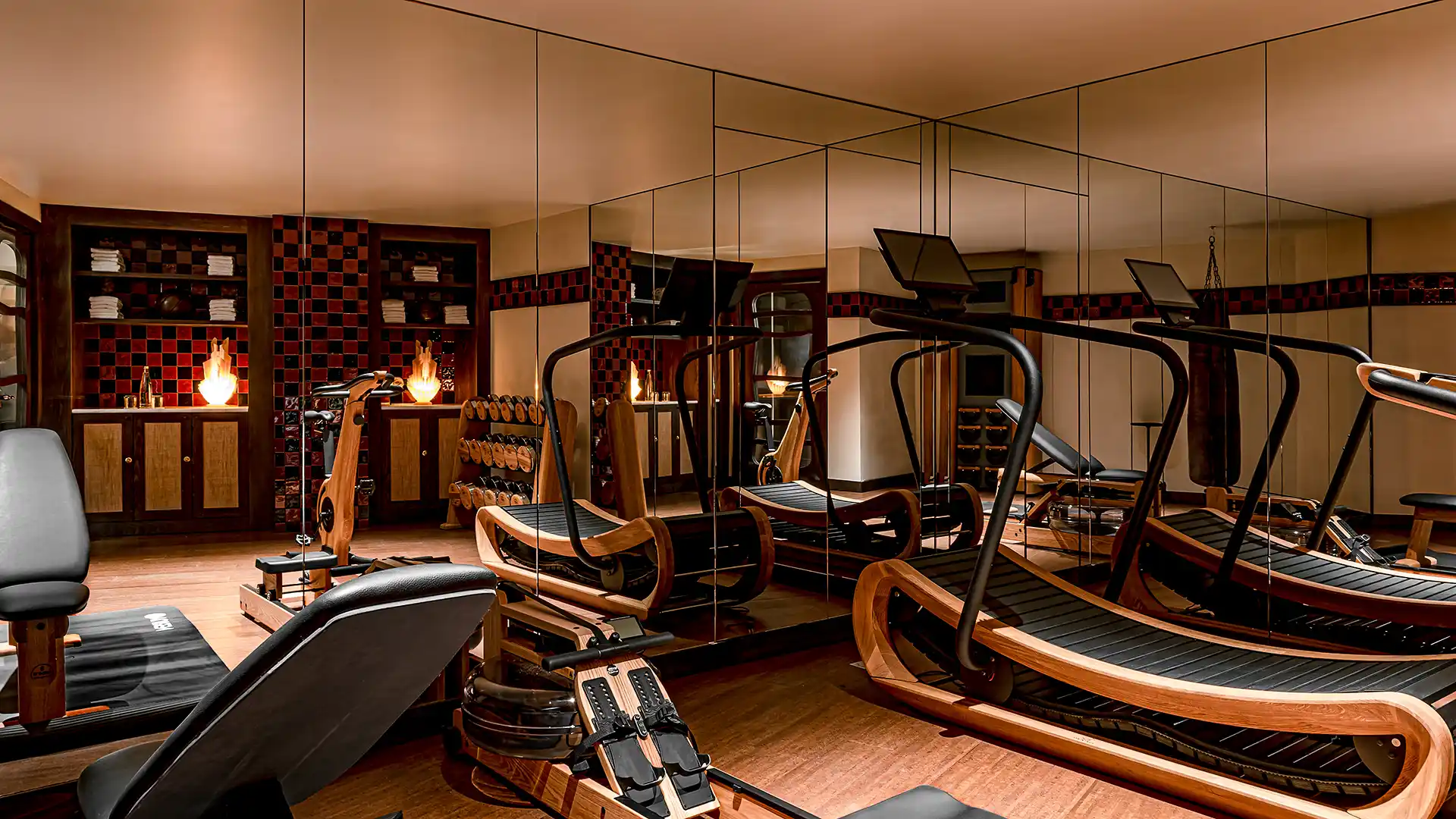 Salle de sport haut de gamme avec tapis de course en bois rameur haltères et miroirs Château des Fleurs