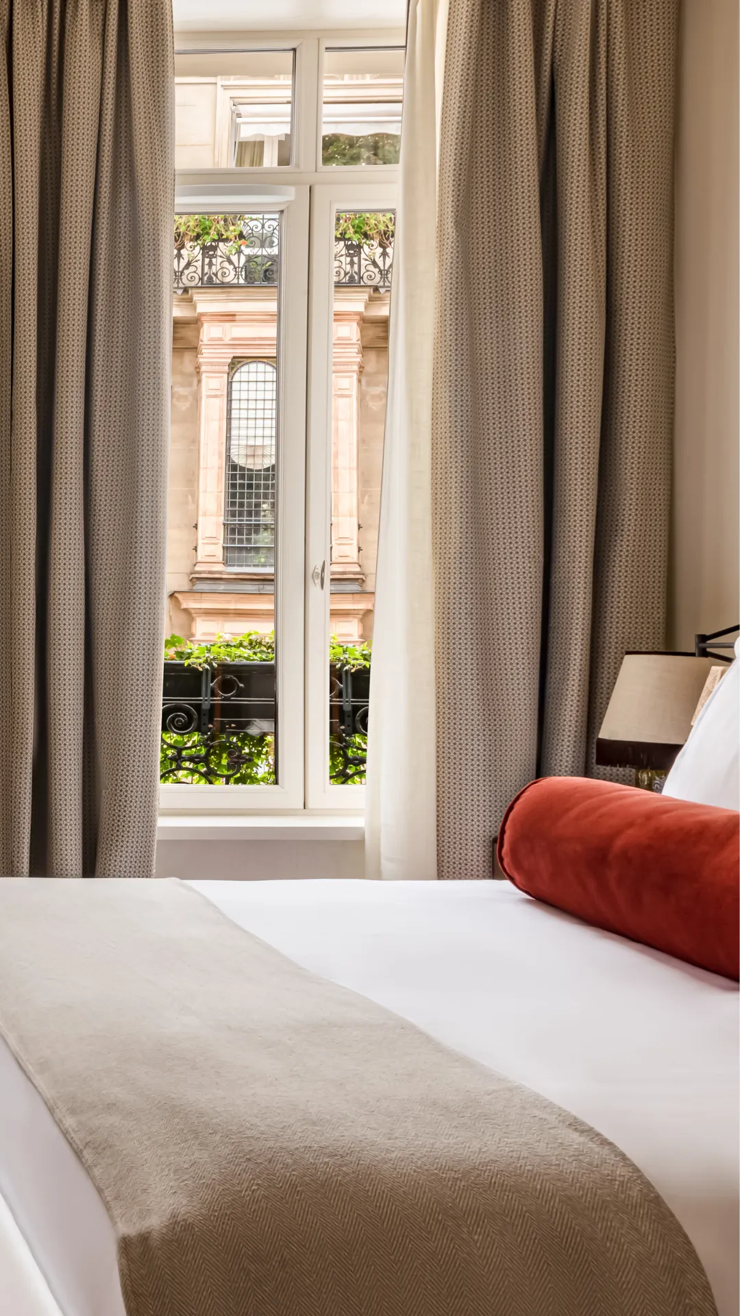 Détail de la tête de lit velours avec coussin bolster terracotta lampe de chevet et table de nuit Château des Fleurs