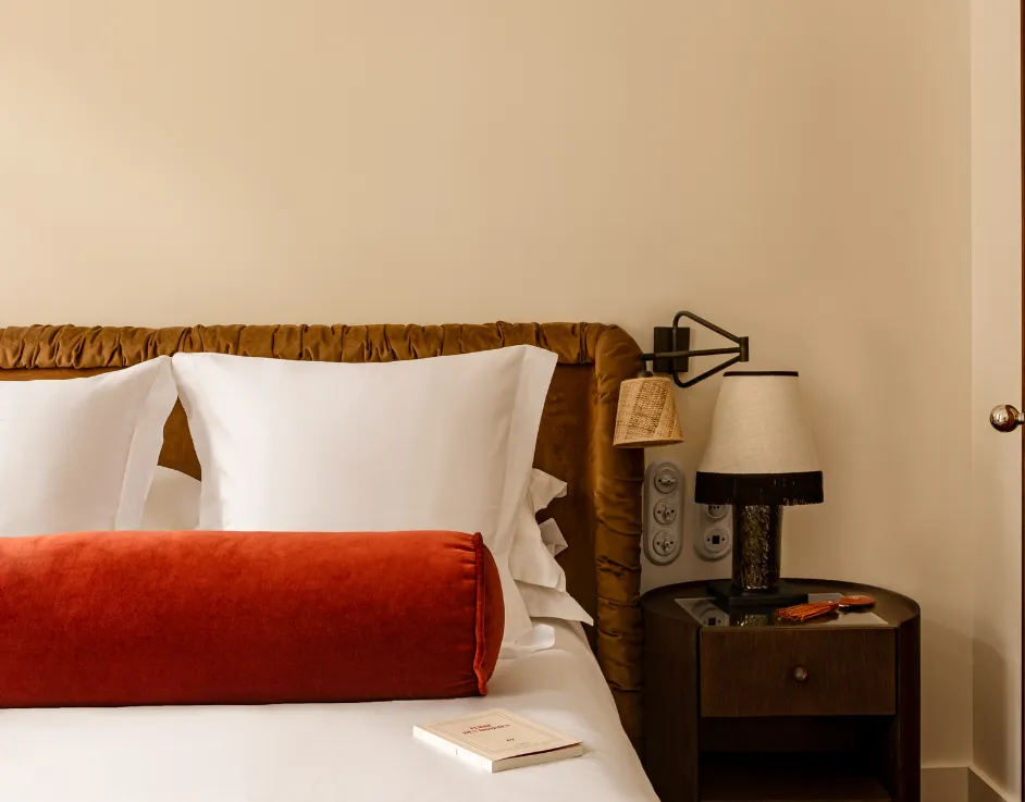 Détail de la tête de lit velours avec coussin bolster terracotta lampe de chevet et table de nuit Château des Fleurs