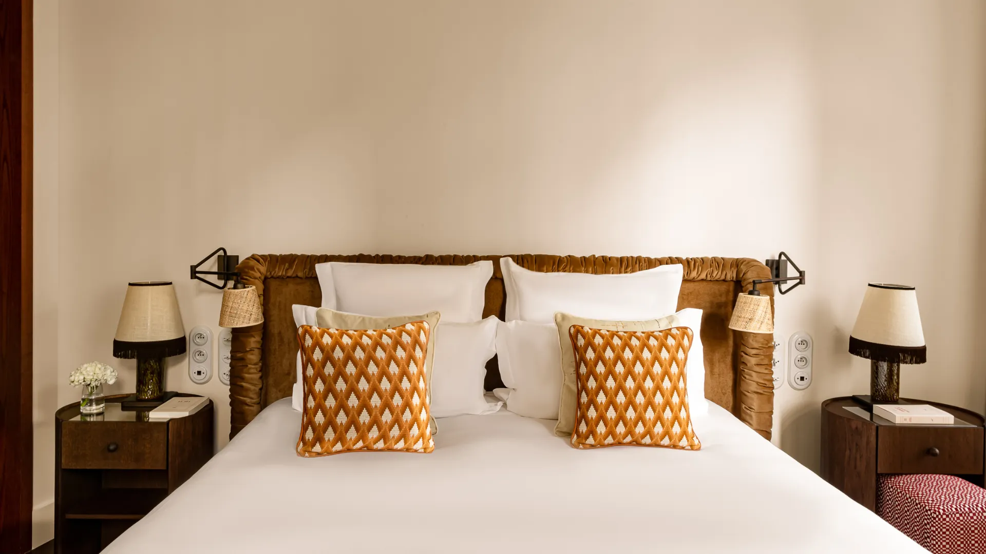 Tête de lit face avec coussins motif géométrique orange et tables de chevet symétriques Château des Fleurs