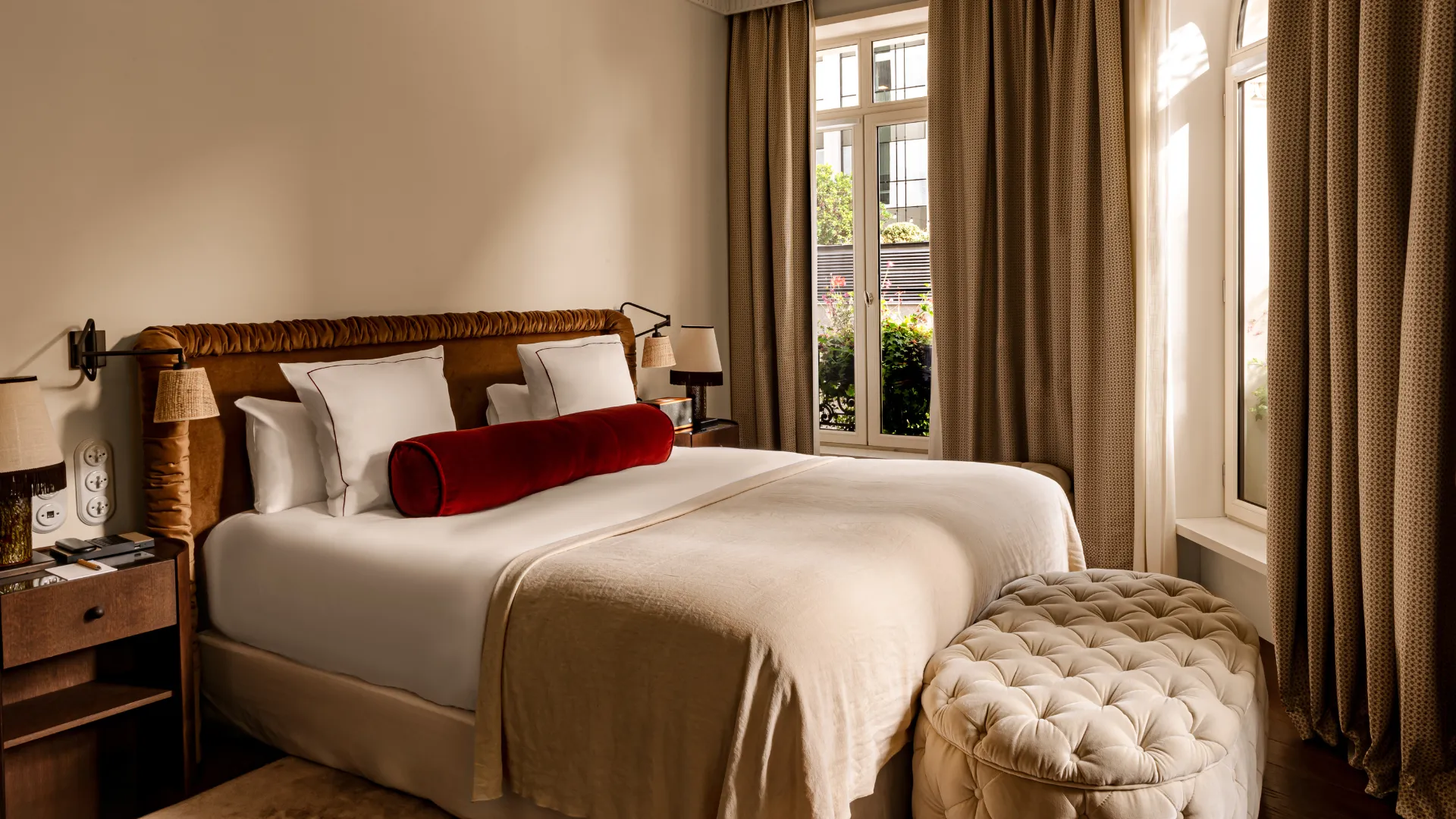 Lit king size avec tête de lit capitonnée pouf en pied de lit et porte-fenêtre donnant sur balcon Château des Fleurs