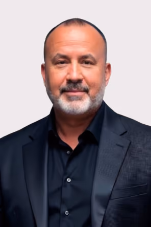 Smiling middle-aged man in a light blue Inmark Life Science shirt against a white background.